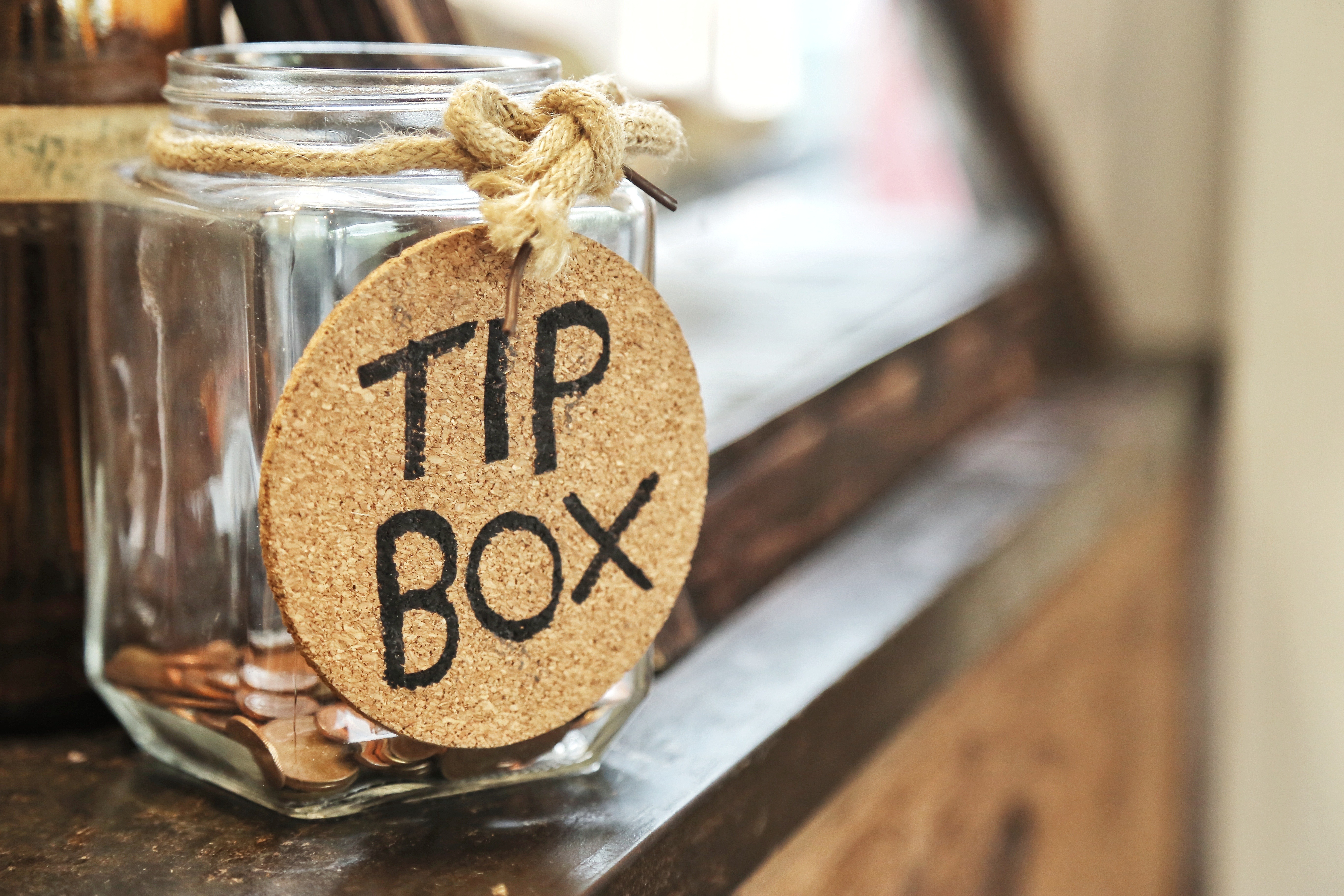 Stock photo 721260262 - Vintage retro glass jar with hemp rope tie tip box  tag and few coins inside on wood counter